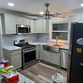 Kitchen renovation with new sage cabinets, subway tile backsplash, and stainless appliances